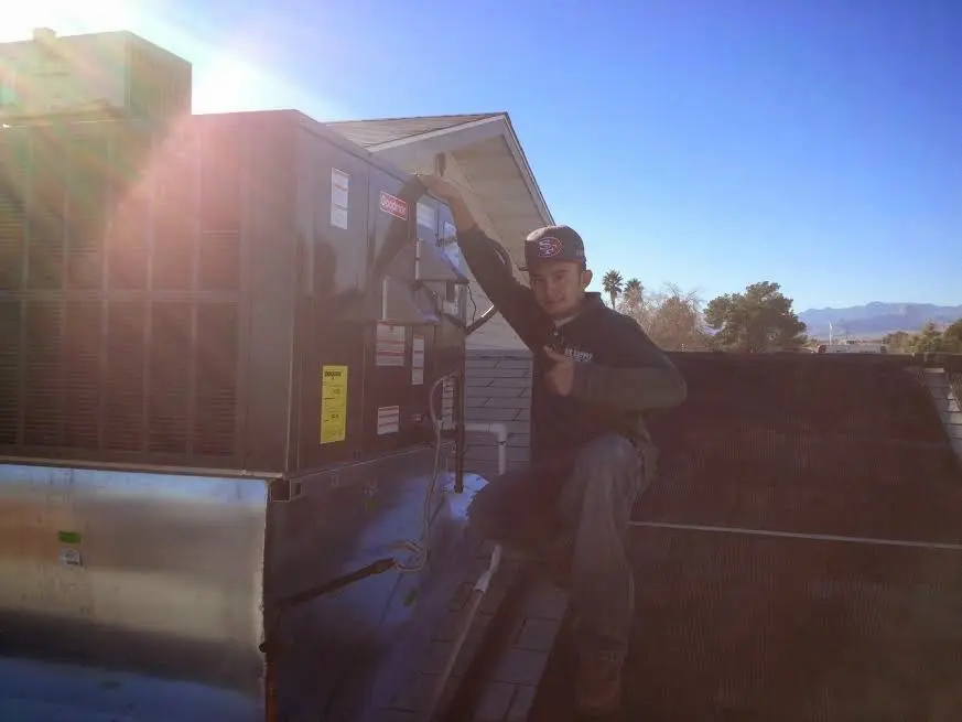 HVAC technician performing Air Duct Repair on a rooftop unit in San Marcos